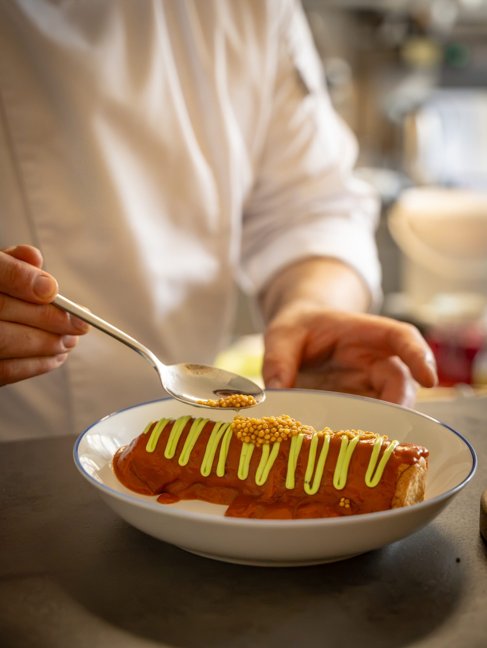 Sebastian Kraus bereitet eine Currywurst im Cafe Schweigert in Bad Liebenzell zu.
